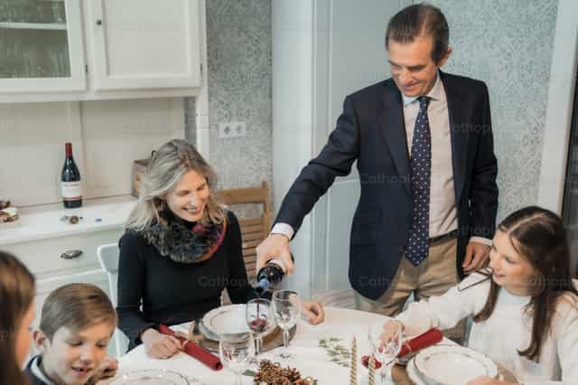 Vader van een gezin die wijn inschenkt - Katholieke stockfoto's - Foto door Almures Studio