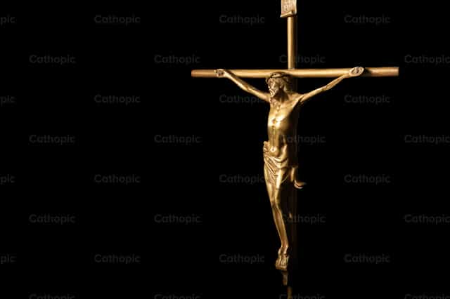 Crucifijo dorado con fondo oscuro - Banco de imágenes católicas - Fotografía por Piero Insfran