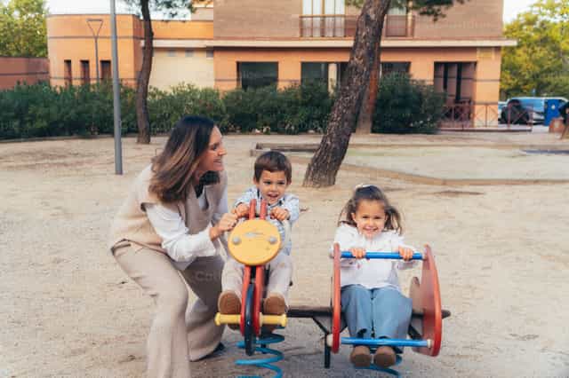 Mutter und Kinder spielen im Park - Katholische Stockfotos