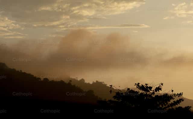 Silhuetas de montanhas ao pôr do sol com neblina - Imagens católicas de stock - Foto de Sandra Otalora