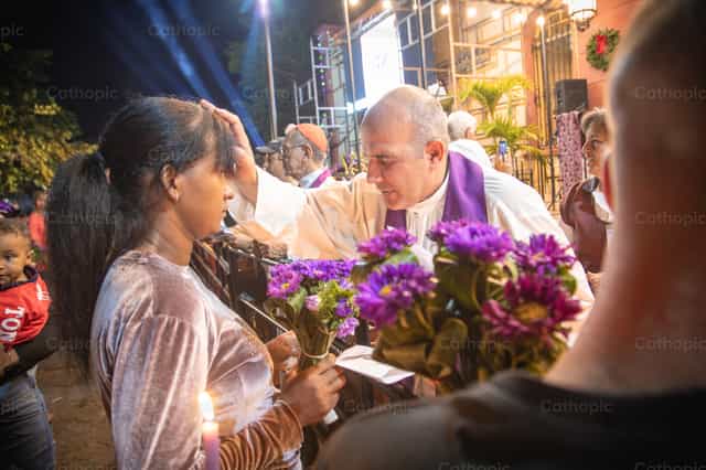 Un sacerdote joven bendice a mujer - Banco de imágenes católicas - Fotografía por Yandry Fernández Perdomo