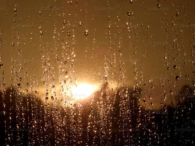 Ventana con gotas de lluvia y reflejos de sol - Banco de imágenes católicas