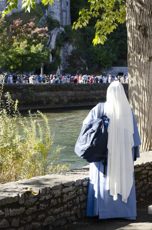 Sister looking at the Grotto of Lourdes - Catholic stock images