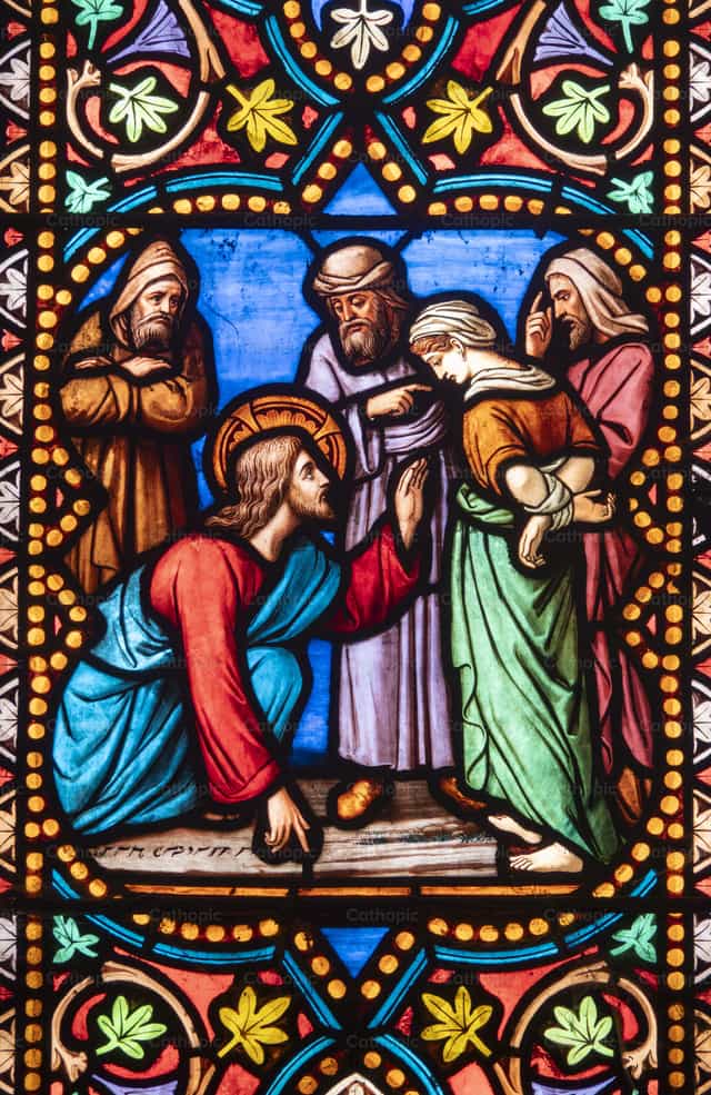 Stained glass of Jesus and the adulteress - Catholic stock images - Photo by Joan Sutter