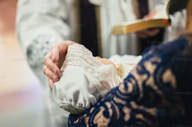 Priest and godparents walking inside of the church | Cathopic
